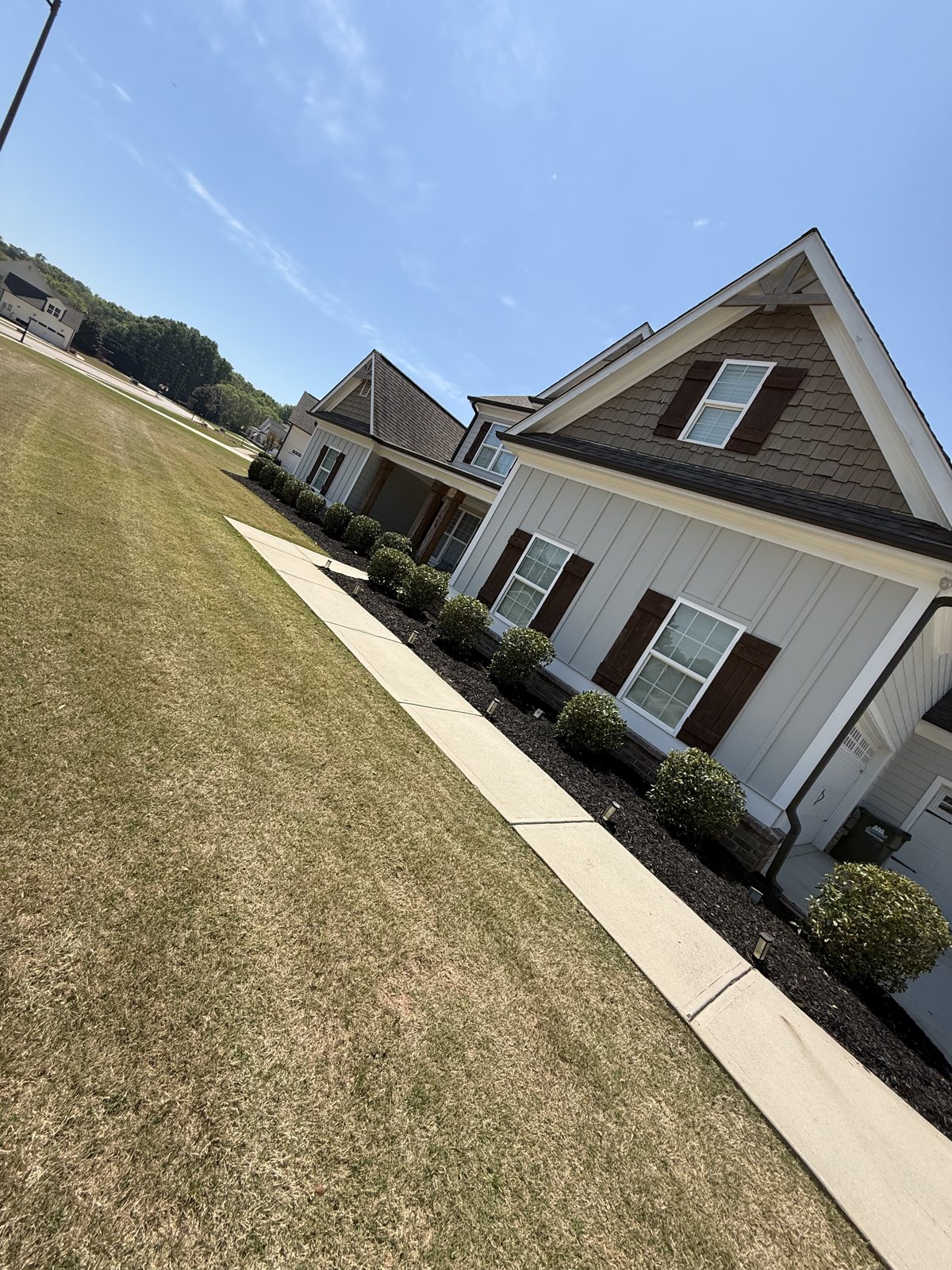 Freshly maintained lawn with dark mulch beds and neatly trimmed shrubs